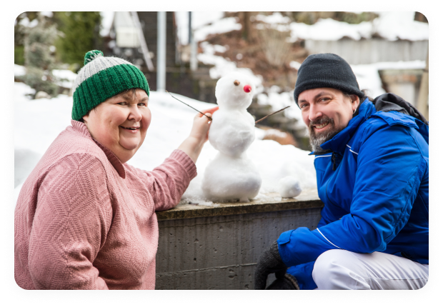 Hombre y mujer haciendo un muñeco de nieve